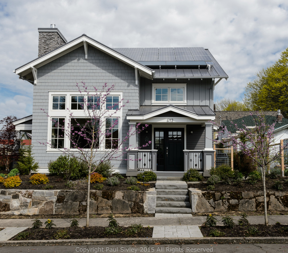 Imagen de fachada gris de estilo americano de dos plantas con revestimiento de madera y tejado a dos aguas