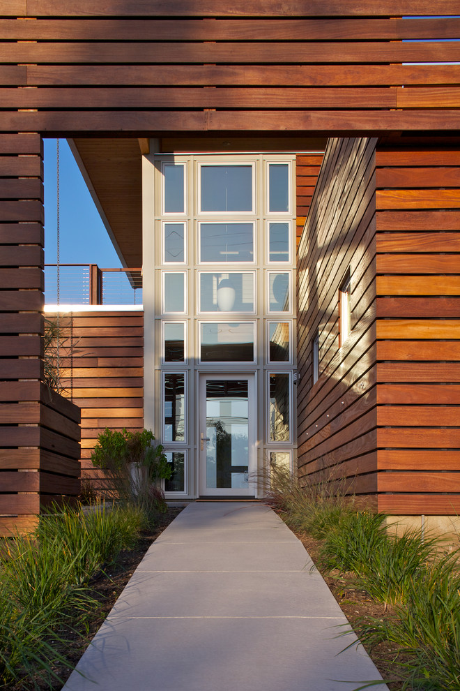 Inspiration pour une grande façade de maison marron design en bois à un étage avec un toit plat.