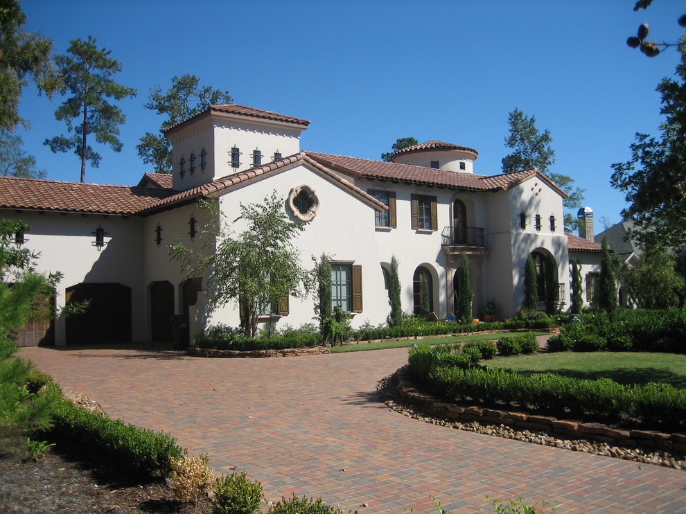 На фото: большой, двухэтажный, белый частный загородный дом в средиземноморском стиле с облицовкой из цементной штукатурки, вальмовой крышей и черепичной крышей