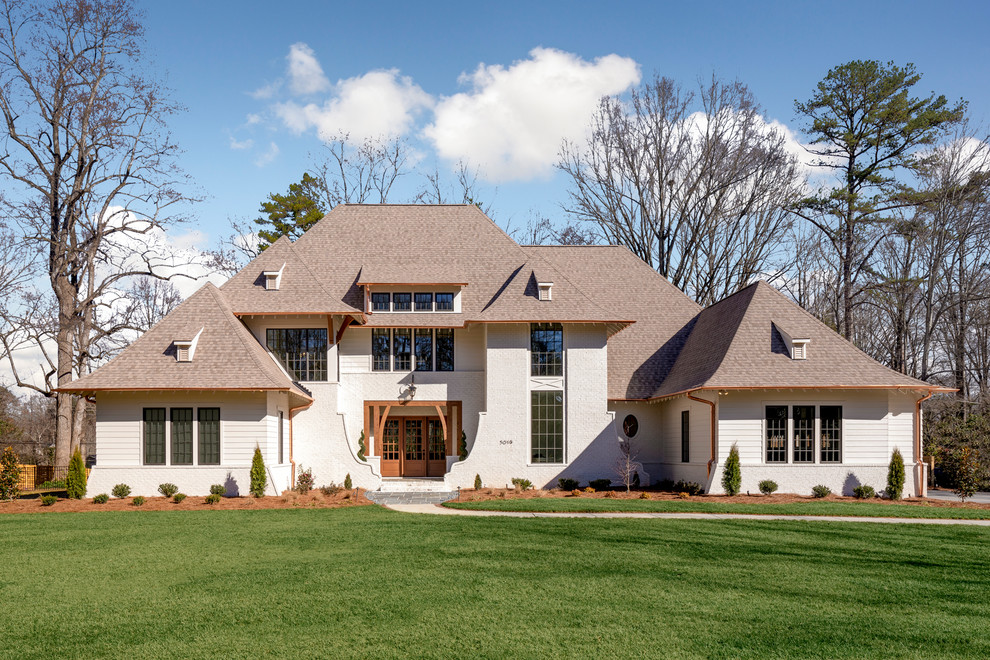 Exemple d'une très grande façade de maison blanche chic à un étage avec un toit en shingle, un revêtement mixte et un toit à quatre pans.