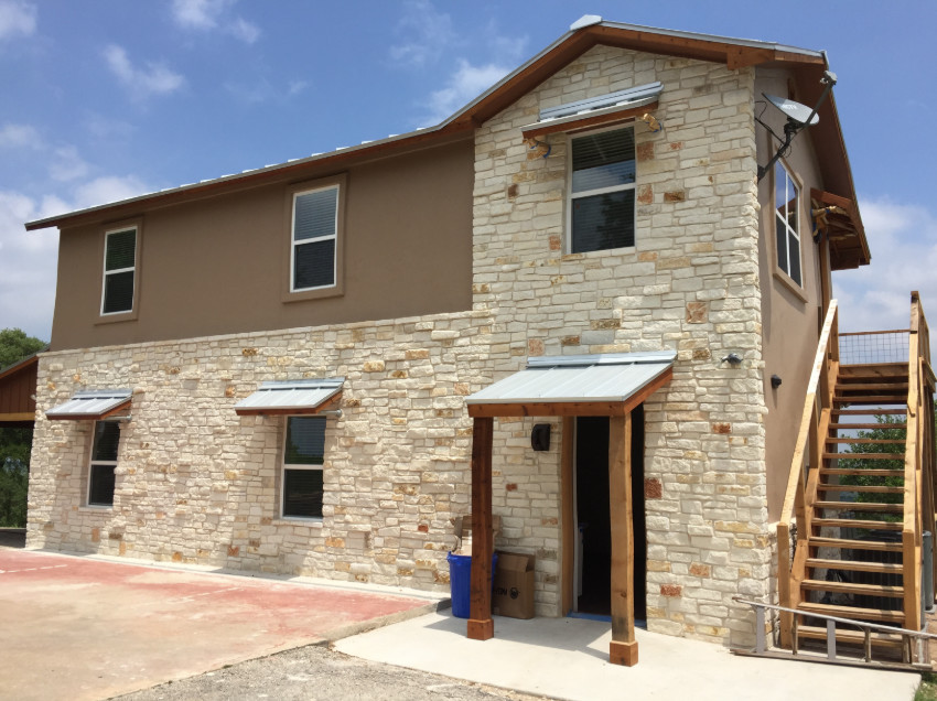 Großes, Zweistöckiges Rustikales Einfamilienhaus mit Mix-Fassade, brauner Fassadenfarbe, Walmdach und Blechdach in Austin