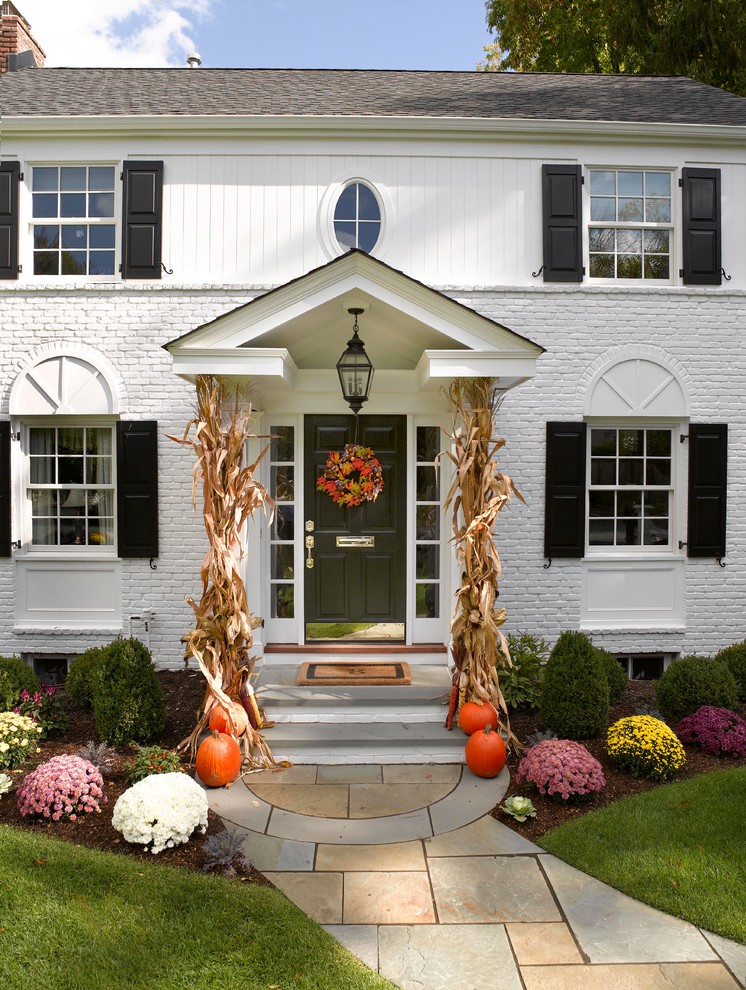 Inspiration for a large timeless white two-story mixed siding gable roof remodel in New York