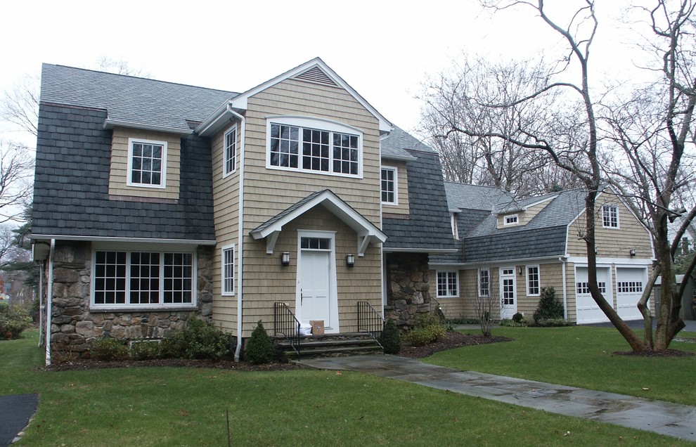 This is an example of a medium sized and beige traditional two floor detached house in New York with vinyl cladding, a half-hip roof and a shingle roof.