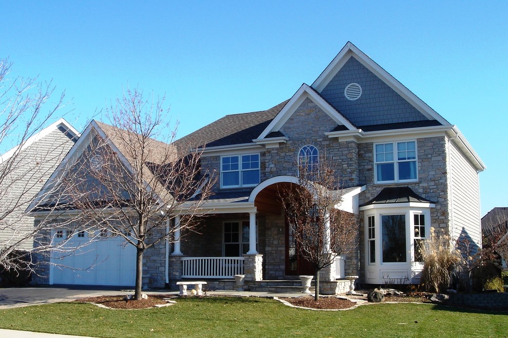 Ejemplo de fachada de casa azul clásica de tamaño medio de dos plantas con revestimiento de piedra, tejado a dos aguas y tejado de teja de madera