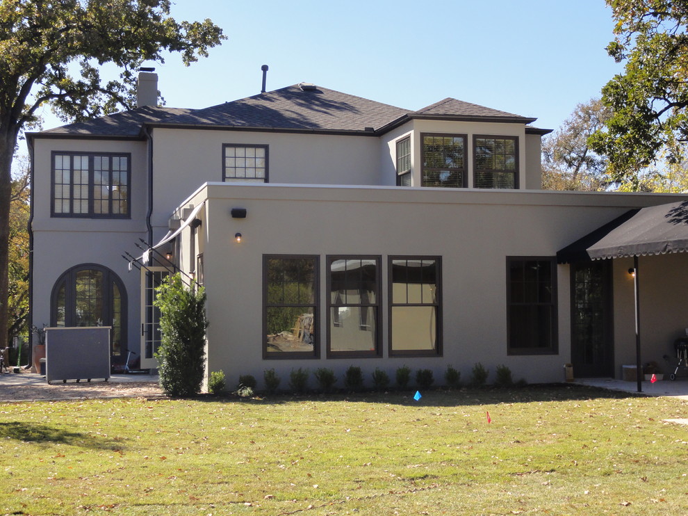 Пример оригинального дизайна: двухэтажный, серый частный загородный дом в классическом стиле с облицовкой из цементной штукатурки, вальмовой крышей и крышей из гибкой черепицы