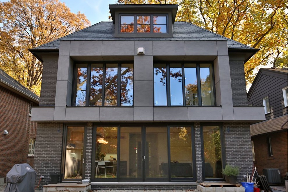 Design ideas for a large and brown contemporary two floor brick house exterior in Toronto with a hip roof.