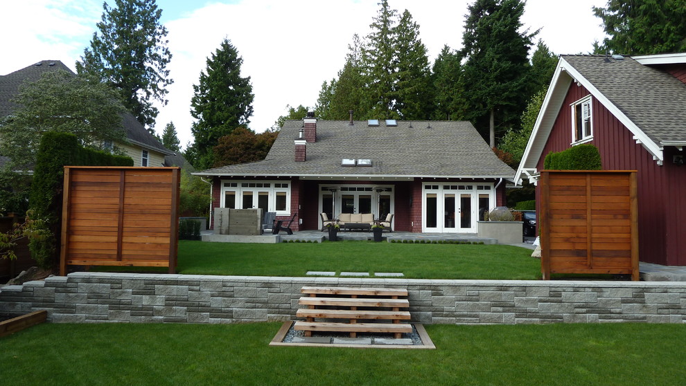 Mittelgroße Urige Holzfassade Haus mit roter Fassadenfarbe und Mansardendach in Vancouver