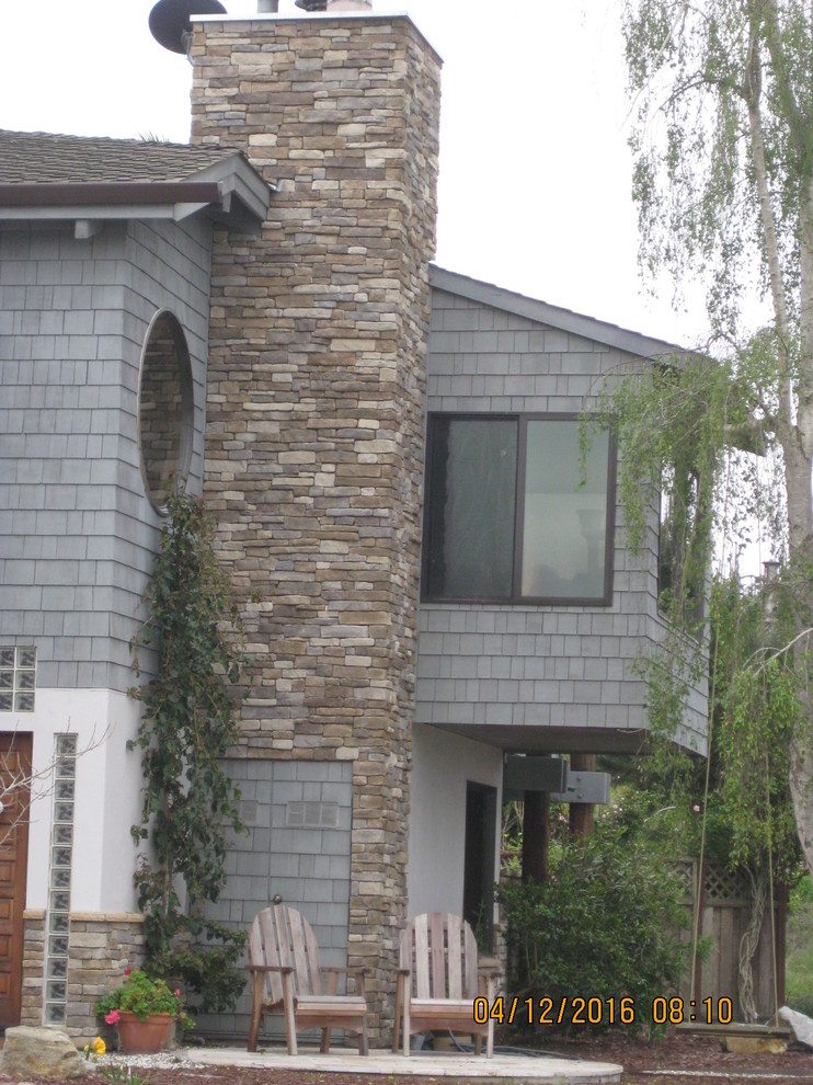 This is an example of a medium sized and gey beach style two floor render house exterior in San Francisco.