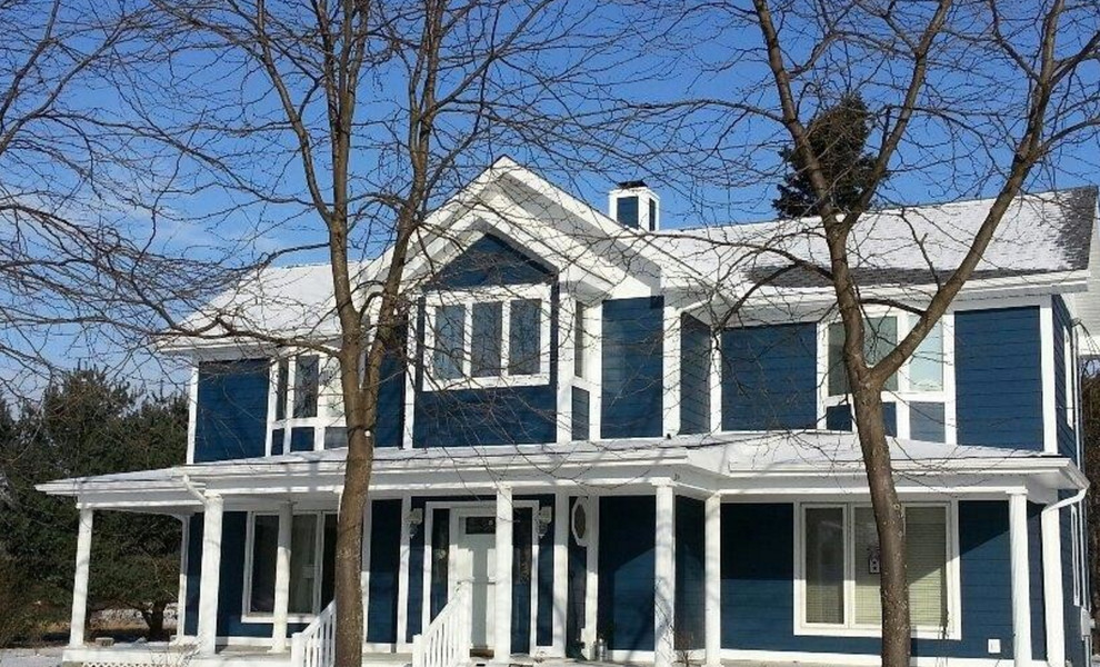 Пример оригинального дизайна: большой, двухэтажный, деревянный, синий дом в классическом стиле с двускатной крышей