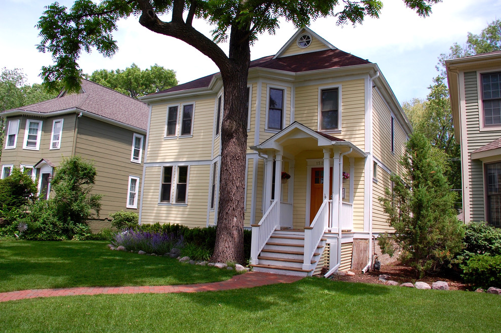Mittelgroßes, Dreistöckiges Landhaus Haus mit Faserzement-Fassade und gelber Fassadenfarbe in Chicago