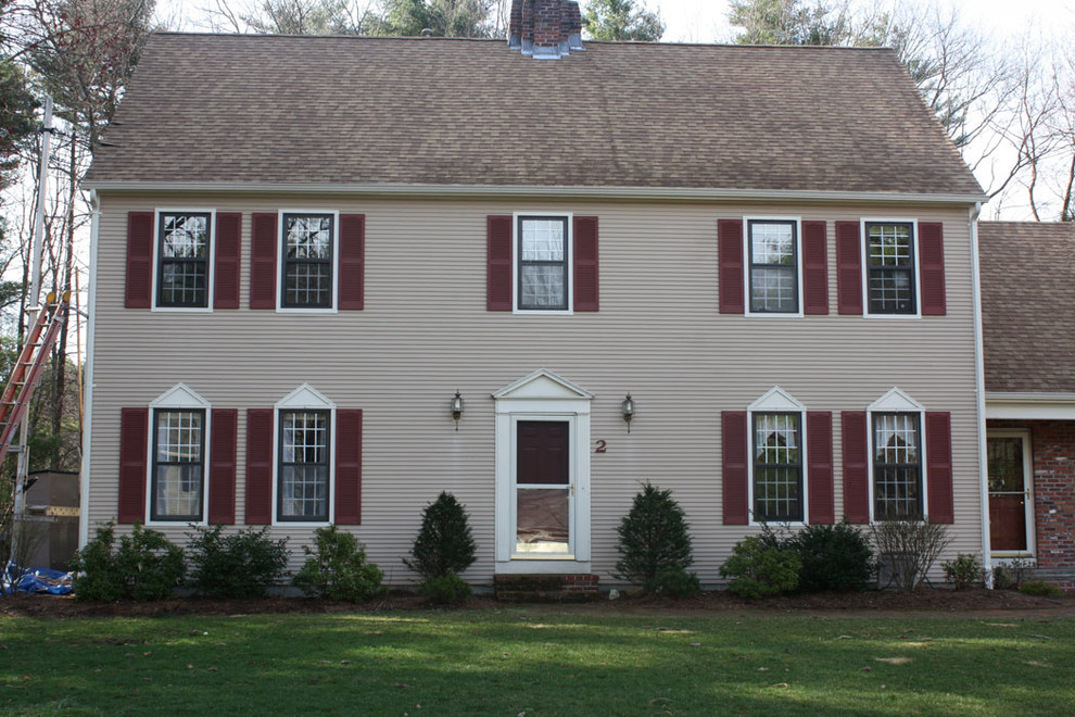 Foto della facciata di una casa beige a due piani con rivestimento in vinile