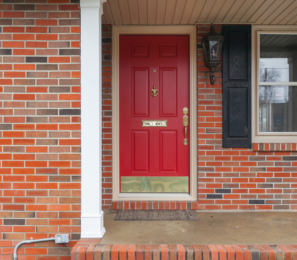 Cette photo montre une façade de maison rouge chic en brique de taille moyenne et de plain-pied avec un toit à deux pans.