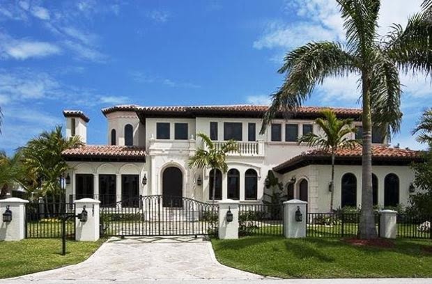 Large and white mediterranean two floor concrete detached house in Miami with a hip roof and a tiled roof.