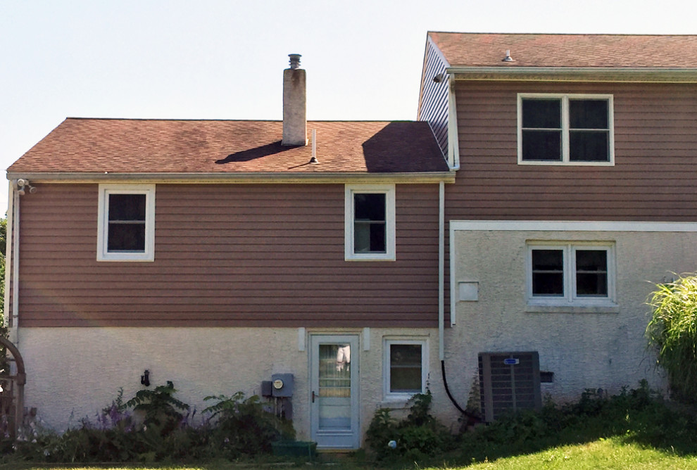 Exempel på ett klassiskt brunt hus, med två våningar och vinylfasad