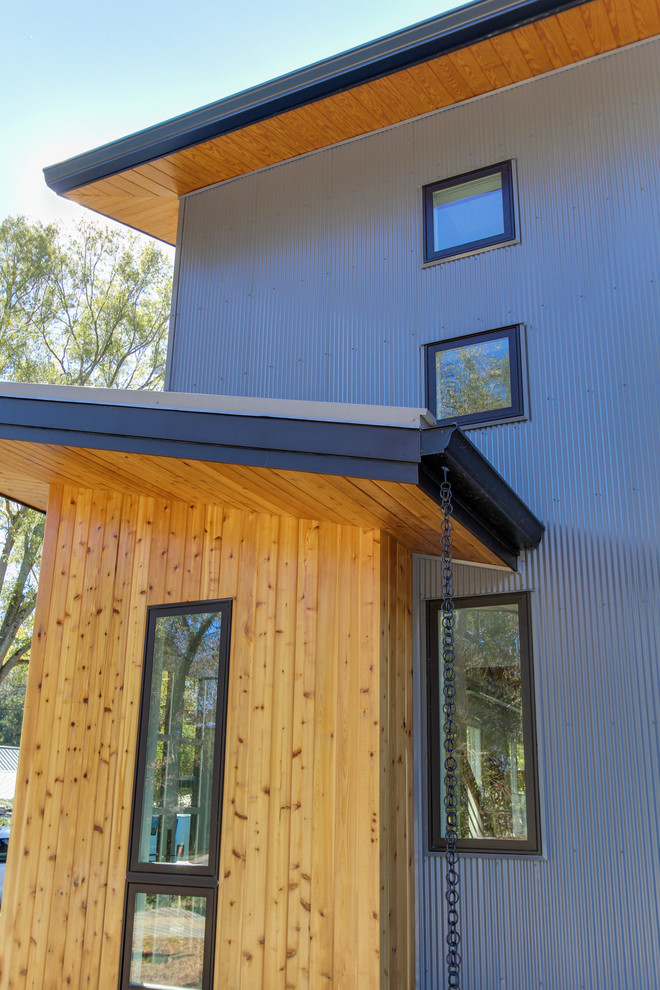 Inspiration for a blue contemporary two floor house exterior in Raleigh with metal cladding and a lean-to roof.