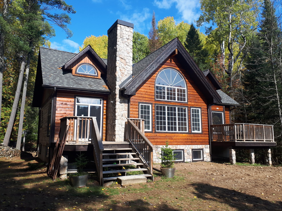 This is an example of a medium sized and brown rustic two floor detached house in Ottawa with wood cladding, a pitched roof and a shingle roof.