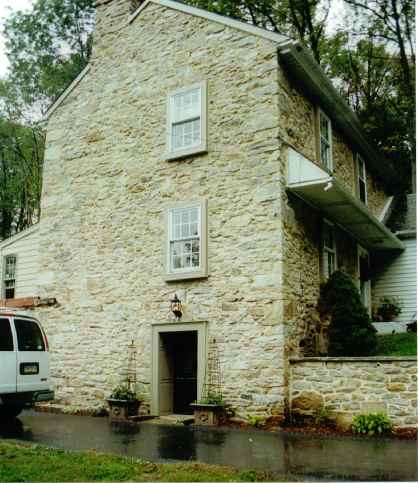Foto della facciata di una casa ampia beige country a due piani con rivestimento in pietra