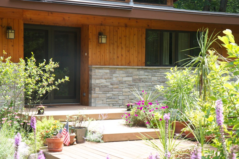 Diseño de fachada marrón moderna de tamaño medio de una planta con revestimiento de piedra y tejado a la holandesa