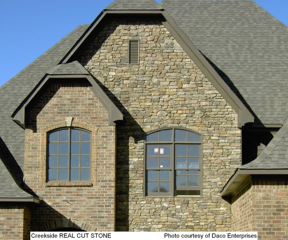Foto de fachada de casa multicolor clásica de tamaño medio de dos plantas con revestimiento de piedra, tejado a dos aguas y tejado de teja de madera