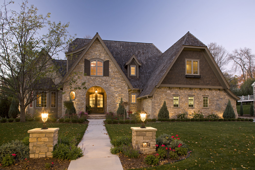Cette image montre une façade de maison en pierre de taille moyenne et à un étage avec un toit à croupette.