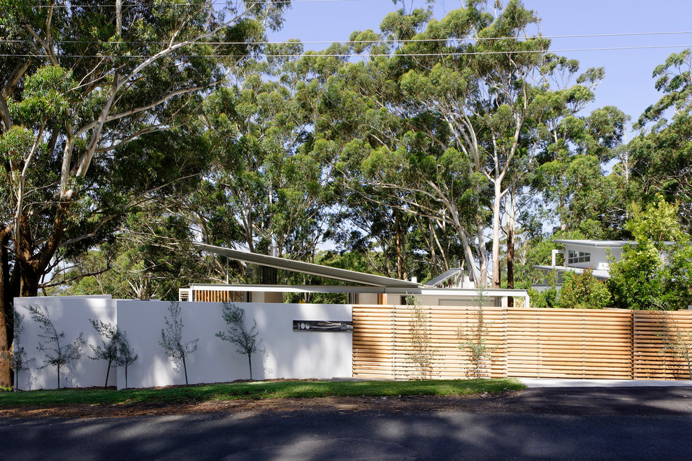 Photo of a medium sized and white contemporary two floor detached house in Sydney with wood cladding, a flat roof and a metal roof.
