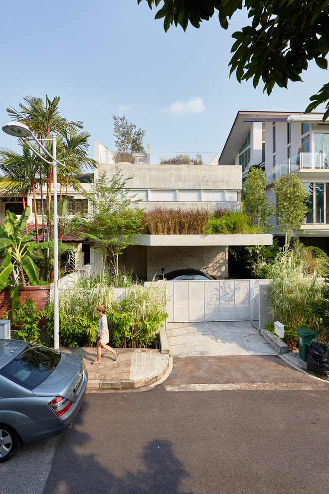 Cette photo montre une façade de maison grise moderne à un étage avec un toit plat et un toit végétal.