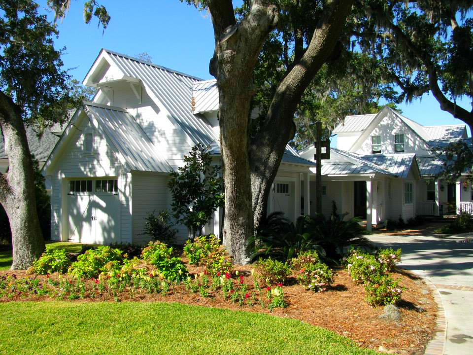 Ejemplo de fachada blanca de estilo de casa de campo de tamaño medio de dos plantas con revestimiento de madera y tejado a dos aguas