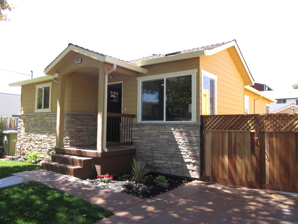 Ispirazione per la facciata di una casa piccola gialla american style a un piano con rivestimento in legno e tetto a capanna