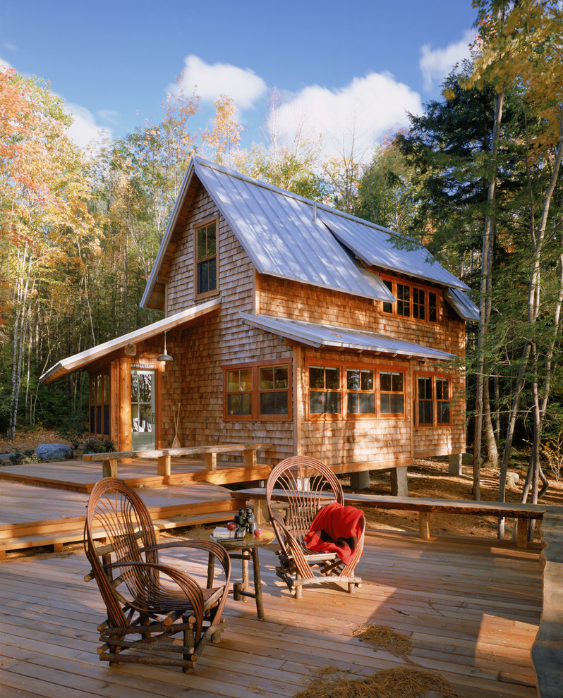На фото: маленький, двухэтажный, деревянный дом в стиле рустика для на участке и в саду, охотников с