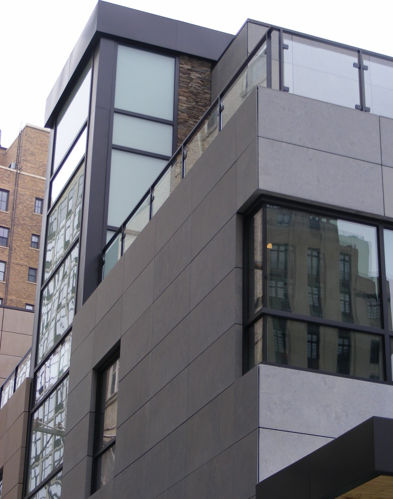 Ejemplo de fachada gris actual extra grande de tres plantas con revestimiento de metal