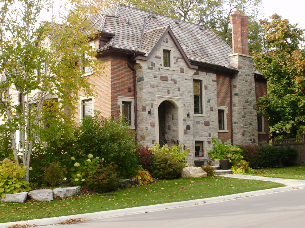 Inspiration for a red traditional two floor brick house exterior in Toronto with a hip roof.