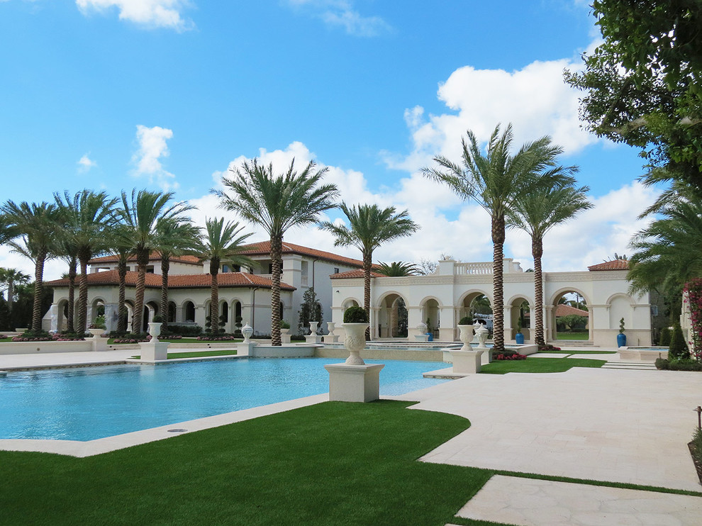 Large tuscan beige two-story stone exterior home photo in Miami
