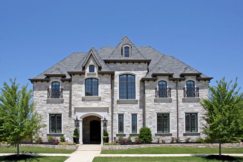Пример оригинального дизайна: двухэтажный, огромный, серый дом в стиле неоклассика (современная классика) с облицовкой из камня