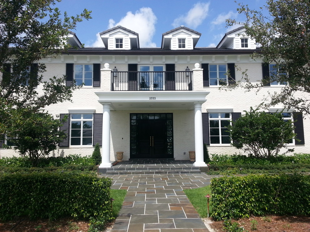 Foto della facciata di una casa bianca classica con rivestimento in mattoni