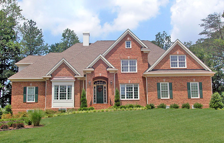 Design ideas for a large and beige classic two floor brick house exterior in Other with a pitched roof.