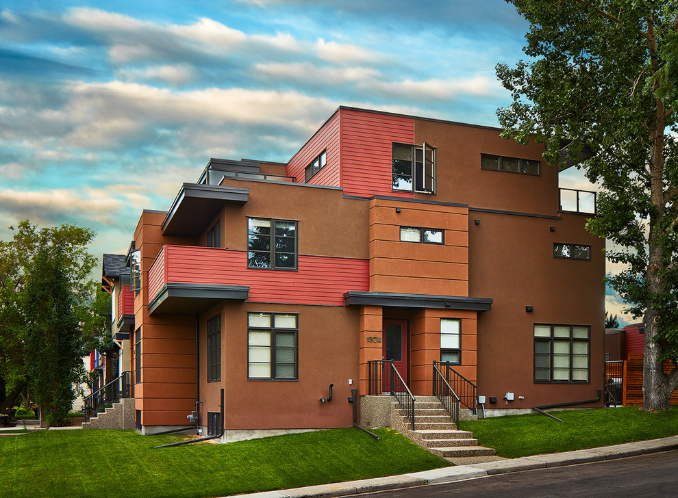 Cette image montre une façade de maison marron design en stuc à deux étages et plus et de taille moyenne avec un toit plat.