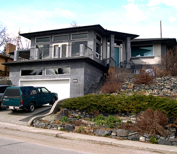 Idées déco pour une façade de maison grise contemporaine en pierre de plain-pied et de taille moyenne avec un toit à croupette.