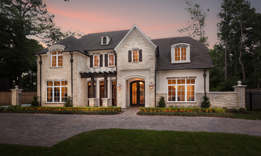 Example of a large transitional beige two-story stone exterior home design in Houston