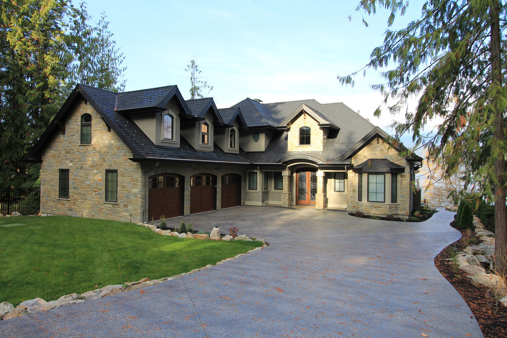 На фото: большой, двухэтажный, бежевый дом в классическом стиле с облицовкой из камня и двускатной крышей с