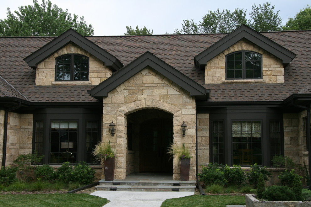 Mid-sized elegant brown two-story stone exterior home photo in Omaha with a shingle roof