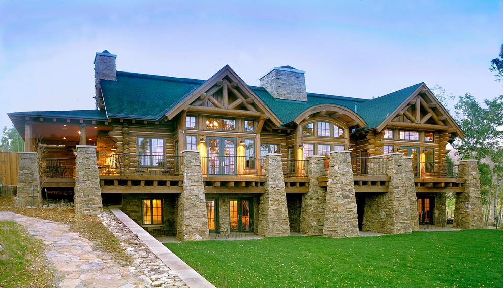 Aménagement d'une très grande façade de maison marron montagne en bois à un étage avec un toit à quatre pans.