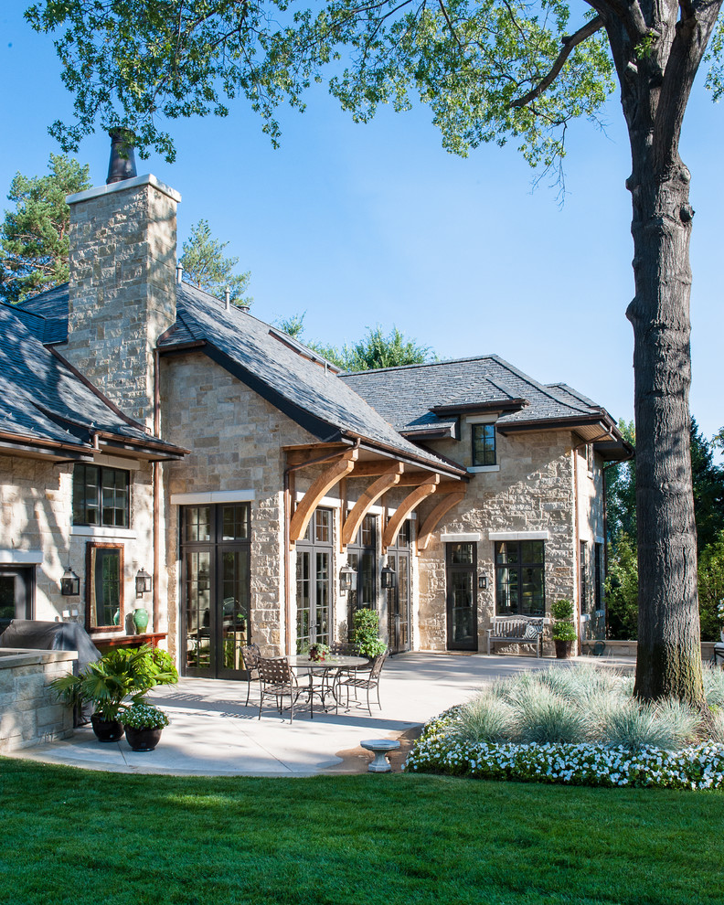 Example of a large classic beige two-story stone exterior home design in Denver with a hip roof