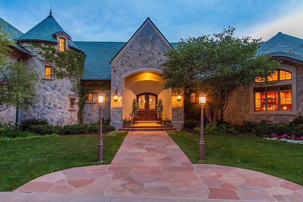 Photo of an expansive and beige classic two floor house exterior in Denver with stone cladding and a hip roof.