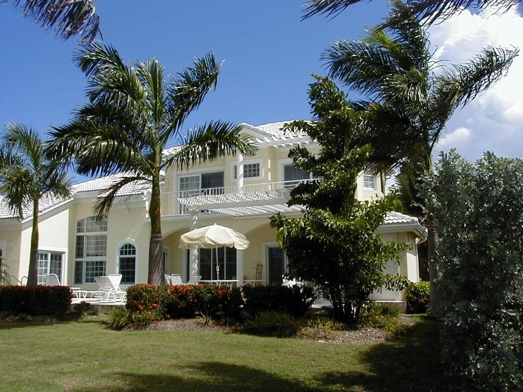 Стильный дизайн: огромный, двухэтажный, белый дом в стиле неоклассика (современная классика) с облицовкой из камня и двускатной крышей - последний тренд