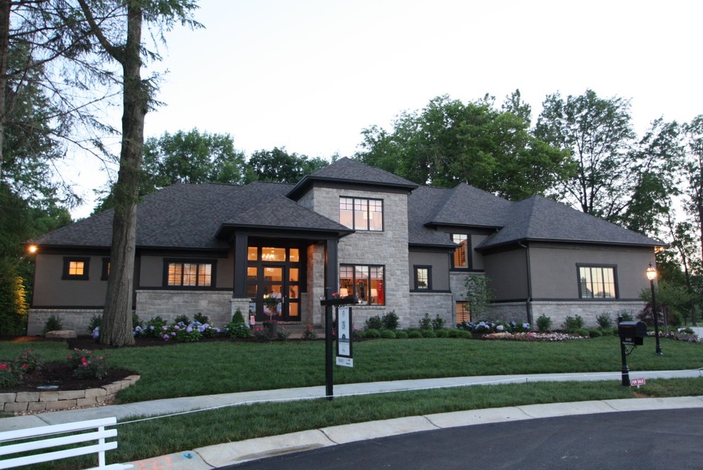 Exemple d'une façade de maison grise chic en pierre de taille moyenne et à un étage avec un toit à quatre pans et un toit en shingle.