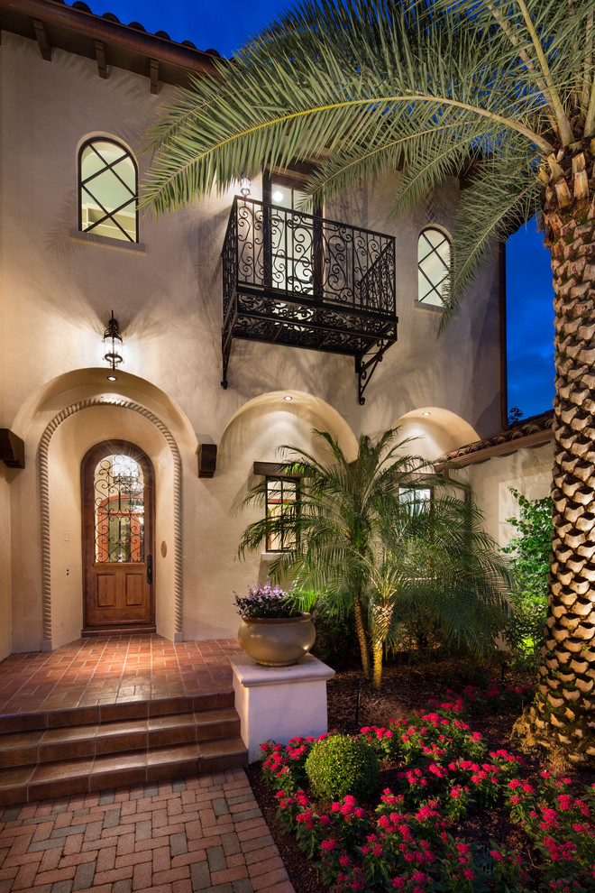 Inspiration for a large mediterranean beige two-story stucco exterior home remodel in Orlando