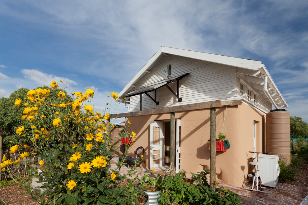 Foto della facciata di una casa piccola beige eclettica a due piani con rivestimento in adobe