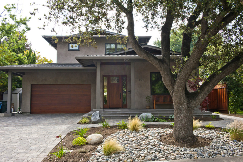 На фото: большой, двухэтажный, серый дом в современном стиле с двускатной крышей и облицовкой из бетона с