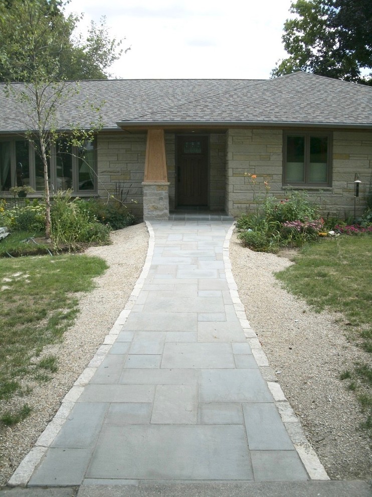 Diseño de fachada de casa gris retro grande de una planta con revestimiento de piedra y tejado a doble faldón