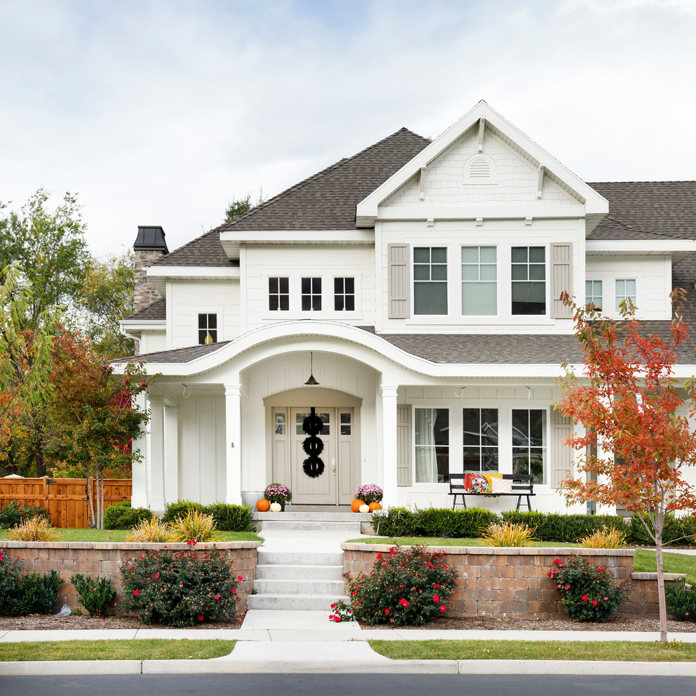 This is an example of a white classic two floor house exterior in Salt Lake City with wood cladding and a hip roof.